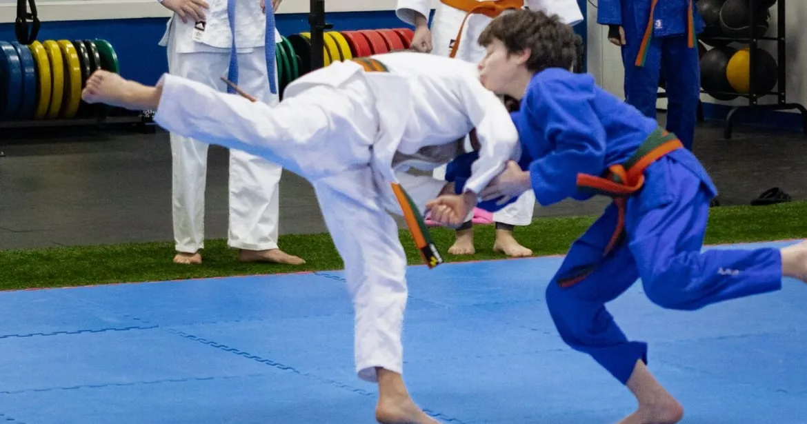 Deux enfants du CSHP en plein combat de judo, kimonos blanc et bleu, sur les tatamis du dojo