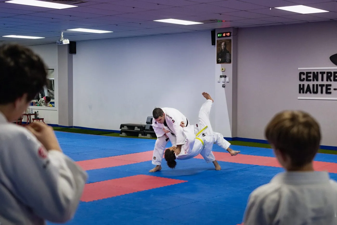 Deux enfants en kimonos blanc et bleu pendant un exercice de judo