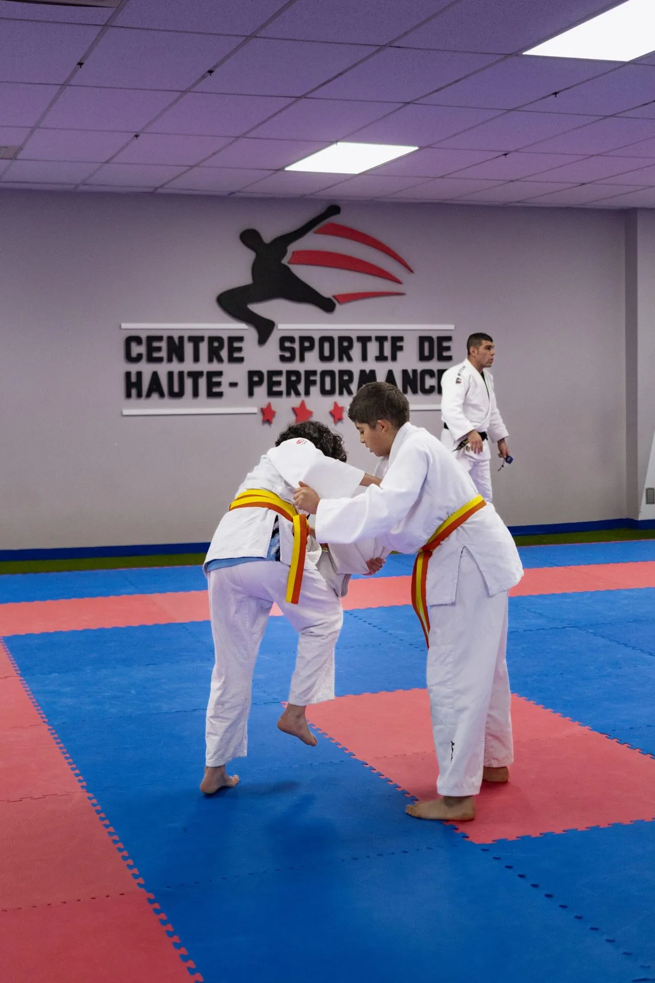 Jeunes karatékas agenouillés en seiza, alignés sur le tatami