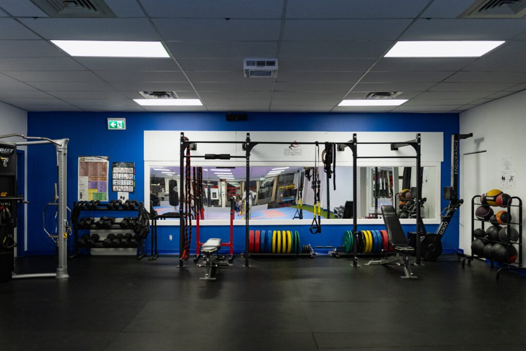 Salle d'entraînement multifonctionnelle au Centre Sportif HP avec équipements de musculation, haltères, et espace de fitness fonctionnel, reflétant un environnement dédié à l'amélioration de la performance athlétique.